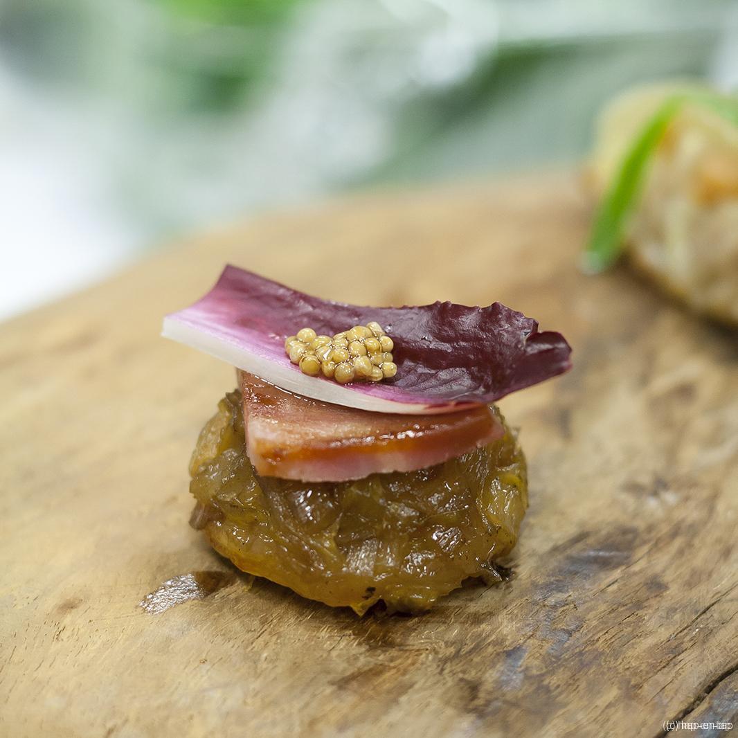 Tarte tatin van witlof, gelakt Breydelspek, opgelegd mosterdzaad